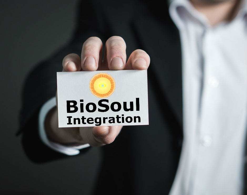 man holding up a BioSoul Integration business card