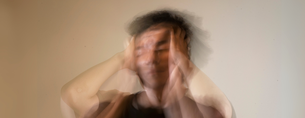 A guy holding his head experiencing anxiety