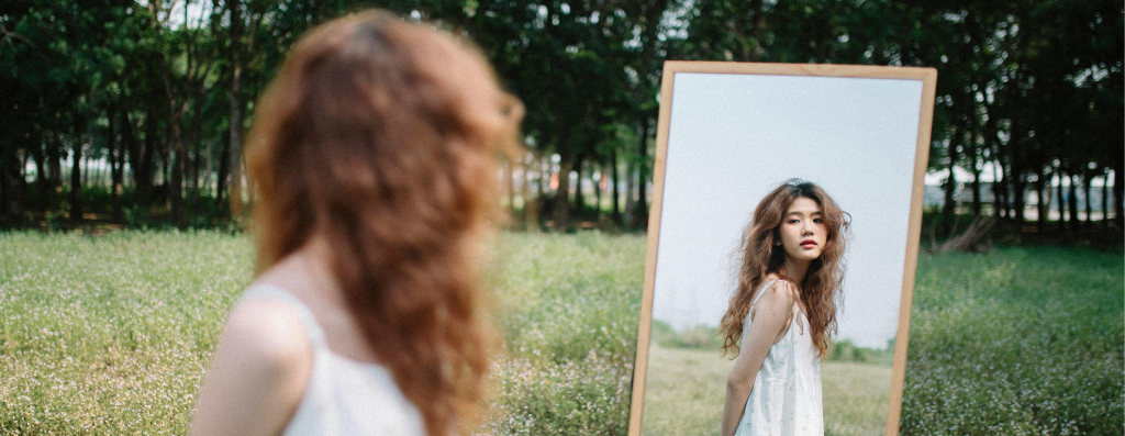 A woman looking at her reflection in the mirror