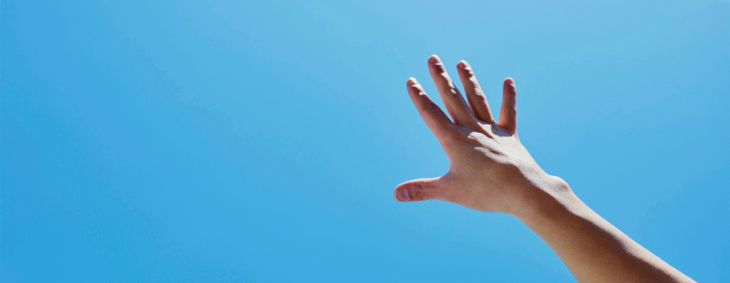 A hand reaching up the sky